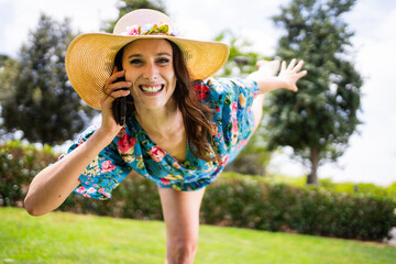 Woman smiling while talking to the mobile and dance outdoors