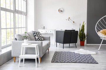 Interior of light living room with white step stool and sofa
