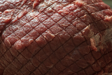 raw roast beef meat on wooden cutting board closeup