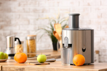 Modern juicer with fresh fruits on table in kitchen