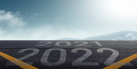 happy new year 2022. road to 2022 goals concept. text 2022 and 2021 written on the road background