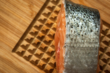 raw salmon filet on wooden cutting board