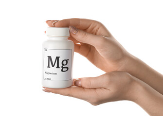 Female hands with bottle of magnesium pills on white background, closeup