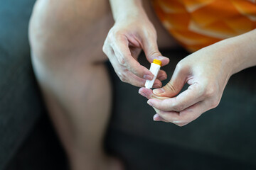 A diabetes patient is using needle device on finger for drawing blood sample to check-up sugar level. Headlthcare action with object photo. Close-up and selective focus.