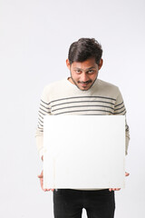 Fototapeta premium Young Indian college student showing blank signboard on white background.