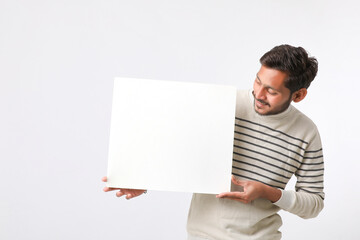 Young Indian college student showing blank signboard on white background.