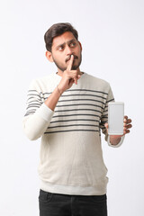 Young indian man showing smartphone screen on white background.