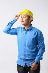 Young Indian engineer wearing yellow color hard hat and giving successful gesture.