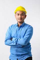 Young Indian engineer wearing yellow color hard hat and giving successful gesture.