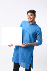 Indian man holding white board, promoting offers on festival season while wearing traditional cloths, standing over white background.