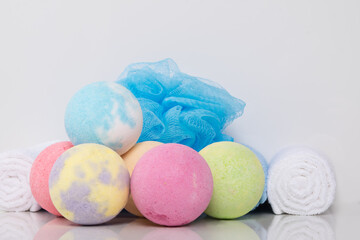 on a white background, a set of balls of multicolored sea salt with a towel and a washcloth
