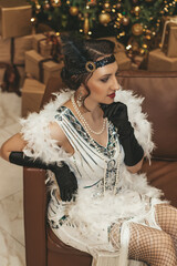Beautiful woman close up on the decorated fir-tree background. Gatsby style