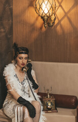 Beautiful woman close up on the decorated fir-tree background. Gatsby style