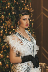 Beautiful woman close up on the decorated fir-tree background. Gatsby style