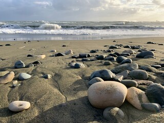 Plakat Sea pebbles on the sandy beach, sea view background