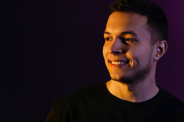 Obraz premium Toned portrait of handsome young man on black background