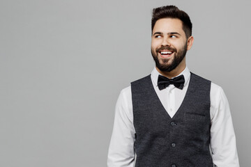 Young barista male waiter butler man 20s wear white shirt vest elegant uniform work at cafe looking aside on workspace isolated on plain grey background studio portrait. Restaurant employee concept.
