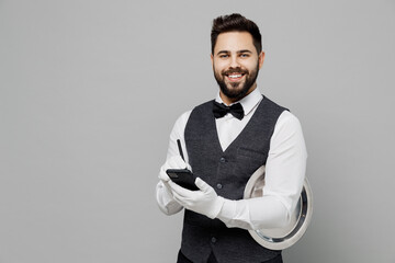 Young fun barista male waiter butler man wear white shirt vest elegant uniform work at cafe write...