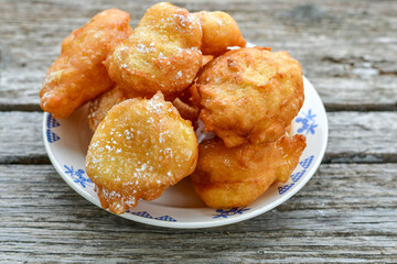 Traditional Bulgarian home made deep fried  patties  covered with sugar  оn rustic backgroud.Mekitsa or Mekica,  on wooden  rustic  background. Made of kneaded dough that is deep fried 