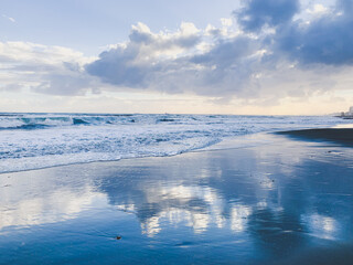 Amazing sky reflection at the sea coast, sand beach, evening time, natural background