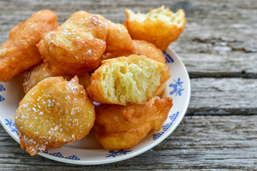Traditional Bulgarian home made deep fried  patties  covered with sugar  оn rustic backgroud.Mekitsa or Mekica,  on wooden  rustic  background. Made of kneaded dough that is deep fried 