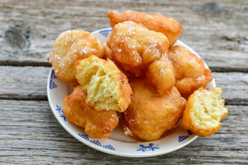 Traditional Bulgarian home made deep fried  patties  covered with sugar  оn rustic backgroud.Mekitsa or Mekica,  on wooden  rustic  background. Made of kneaded dough that is deep fried 