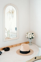 Hat On a Table Next to a Mirror in a Hotel Room