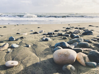 Obraz na płótnie Canvas Sea pebbles on the sandy beach, sea view background
