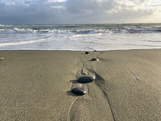 Fototapeta na wymiar Sea pebbles on the sandy beach, sea view background