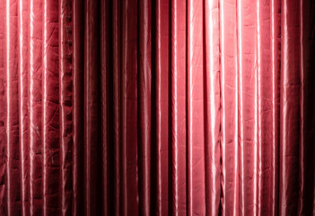 Partially illuminated red theater curtains