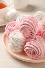 Plate with delicious pink zephyrs on white table, closeup