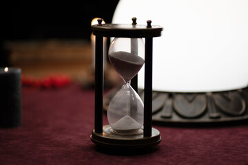 hourglass on the table near the glass ball for fortune telling