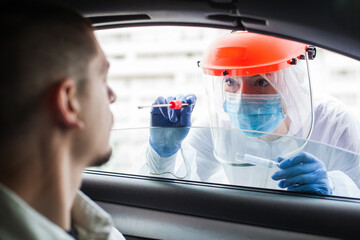 Female medical worker taking PCR swab sample from young male patient