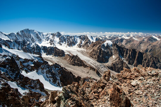 View from the top of Pik Uchitel peak with cross. Ala Archa Alpine National Park Landscape near Bishkek, Tian Shan Mountain Range, Kyrgyzstan, Central Asia.