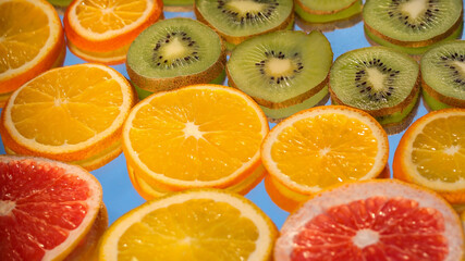 Citrus fruits collection food background oranges lemon kiwi grapefruit fresh fruit backgrounds. Slices of grapefruit lemon orange and kiwi on a sky background. Concept of healthy food, diet.