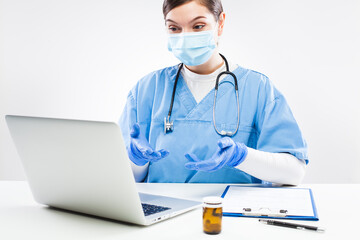 Young female doctor consulting with remote patient over laptop