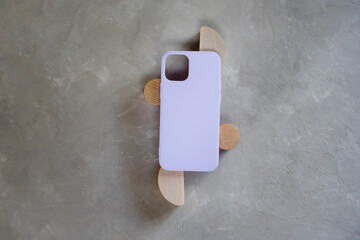 Lilac silicone case for smartphone on a gray textured background. Color concept - very peri color of the year 2022.