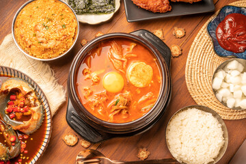 Traditional Korean food, kimchi soup, Korean Fried chicken with spicy sauce  with rice, seaweed,fresh raw crabs marinated,spicy Rice Cake and Kimchi pickle on wooden table.