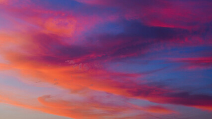 Somptueuses traînées de lumière rouges et oranges, sous des nuages de type Cirrus et Cirrostratus