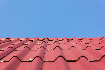View of red roof tiles and blue sky background
