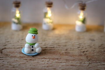 Christmas decor. Miniature powdered sugar snowman stands on a wooden board
