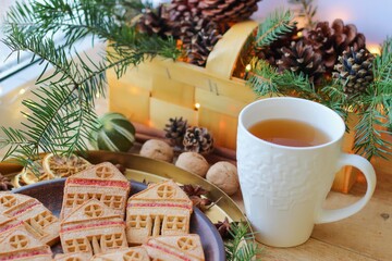Christmas eve. Cookies in shape of houses and cup of tea