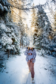 Pregnant woman doing healthy walk in the snowy winter forest