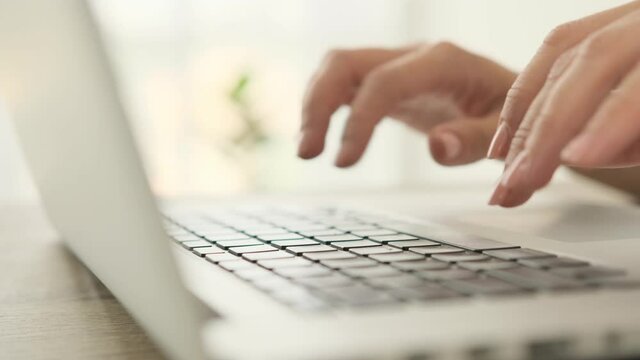 Hands typing on laptop keyboard. Fingers press buttons on pc notebook keypad