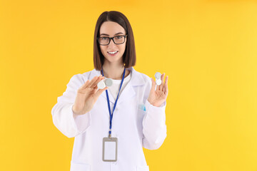 Female doctor with lenses on yellow background