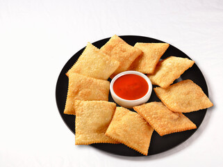 mini pastries served on a round plate with sauce