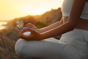 Fototapeta Woman meditating outdoors at sunset, closeup view obraz