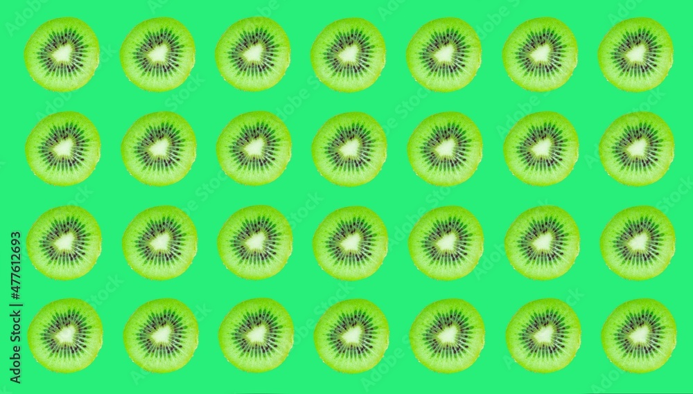 Poster kiwi slices pattern, top view of kiwi slices on green background.