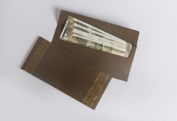 Indian currency notes placed in a decorative paper envelope. Idea for 'Festive cash gift, 'Cash...