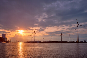 Wind turbines in Antwerp port on sunset.